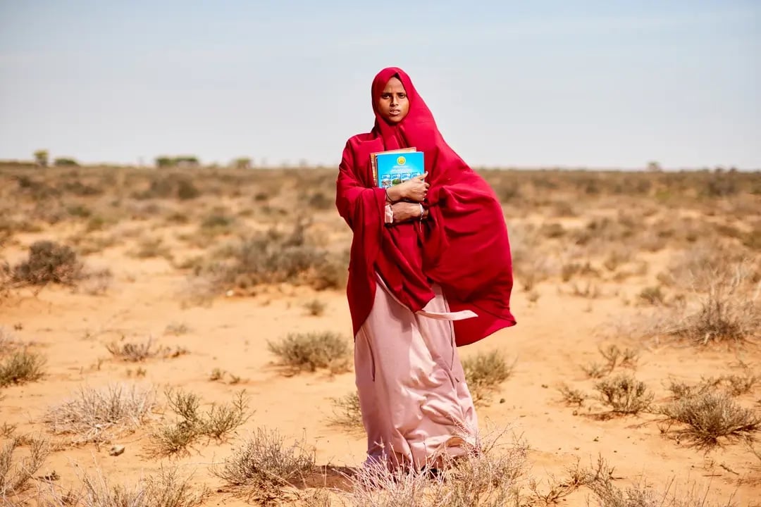 Een meisje uit Somalië, getroffen door de klimaatcrisis, op weg naar school in de woestijn.